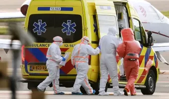 Medics escort a patient, second right, evacuated from the MV Hondius cruise ship with suspected hantavirus infection