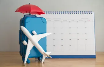 Airplane, suitcase, umbrella and white calendar