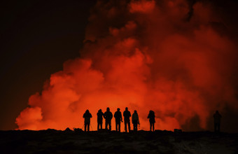 People look at the volcano erupting, north of Grindavík, Iceland