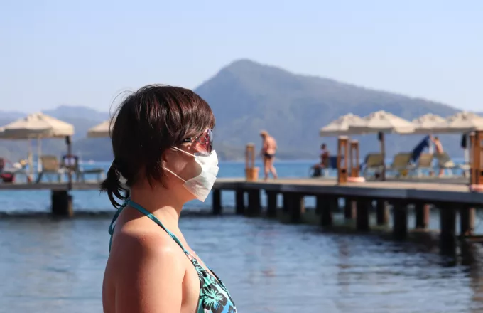Γυναίκα με μάσκα στη θάλασσα 