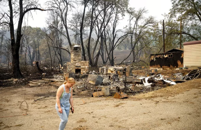 Γυναίκα έξω από καμένο σπίτι στην Καλιφόρνια