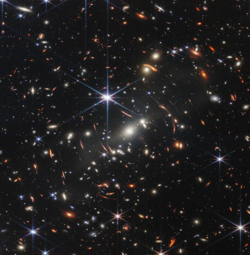 «Η βαθύτερη και ευκρινέστερη υπέρυθρη εικόνα του μακρινού σύμπαντος μέχρι σήμερα», σύμφωνα με τη NASA. Η εικόνα δείχνει το SMACS 0723, όπου μια τεράστια ομάδα σμήνων γαλαξιών λειτουργεί ως μεγεθυντικός φακός για τα αντικείμενα πίσω τους. Ονομάζεται βαρυτικός φακός, αυτό δημιούργησε την πρώτη βαθιά όψη πεδίου του Webb απίστευτα παλιών και μακρινών, αμυδρά γαλαξιών