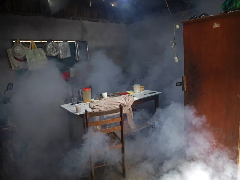 Clouds of insecticide seep into a dining room during a fumigation operation to help control the spread of dengue fever, in downtown Pucallpa, Peru