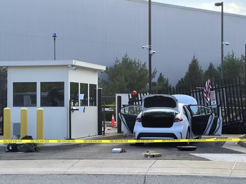 FBI officials inspect a car that rammed into a gate at the FBI building in Pittsburgh