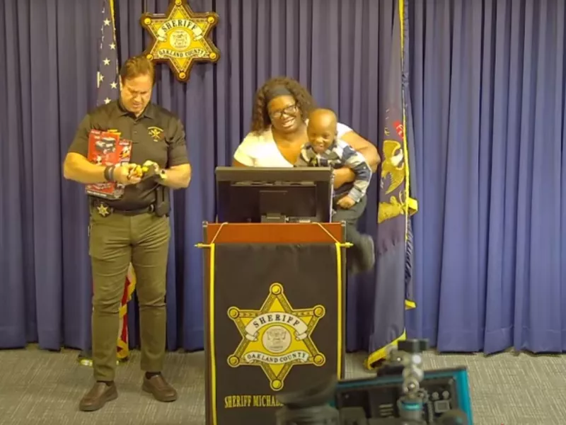 Sheriff Michael Bouchard, Shantell Woods and three-year-old Cody James Williams at a press conference